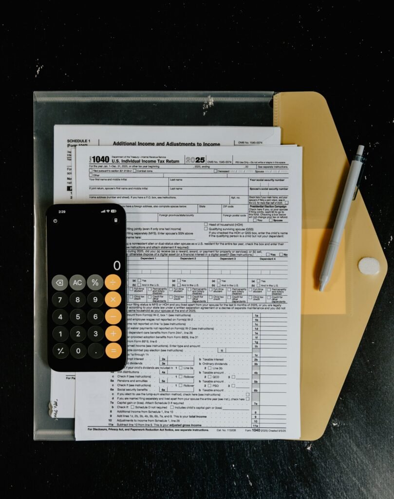 Formularios de impuestos con una calculadora y un bolígrafo sobre un escritorio